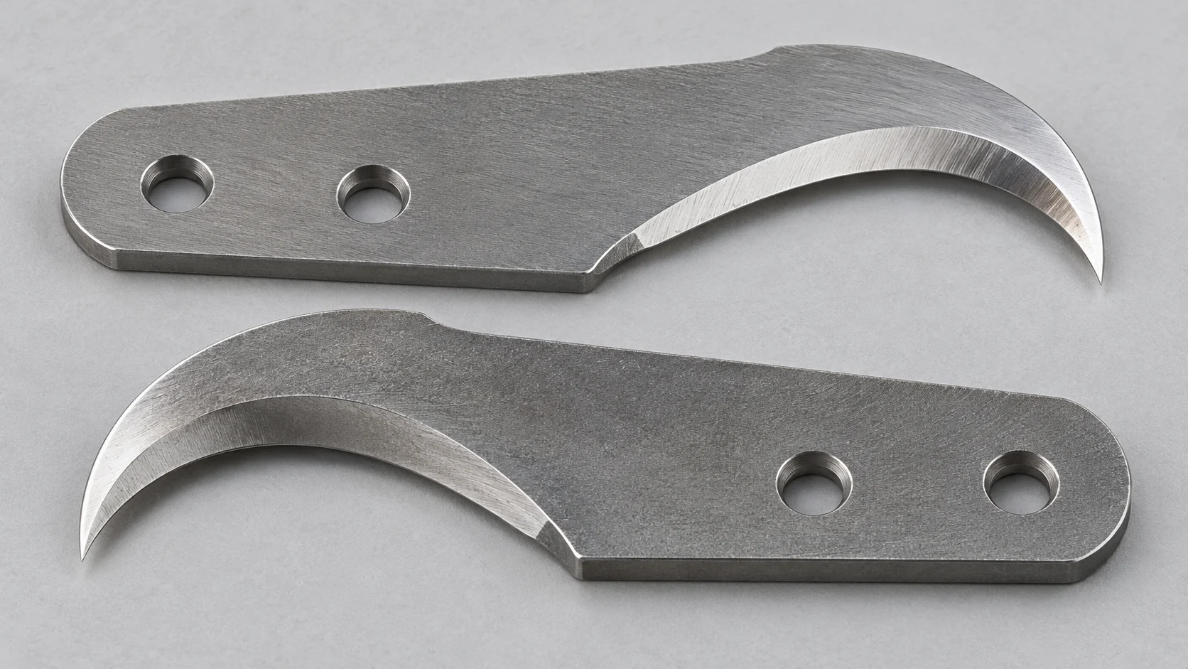 Two hooked profile knives with mounting holes and curved cutting edges